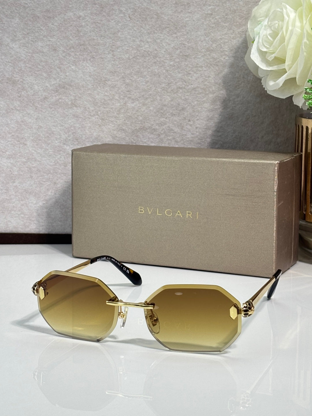 Hexagon sunglasses with yellow-tinted lenses, gold-tone frame and dark blue temples