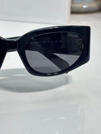 Celine sunglasses, glossy dark frame with dark shield-shaped lenses and Celine logo
