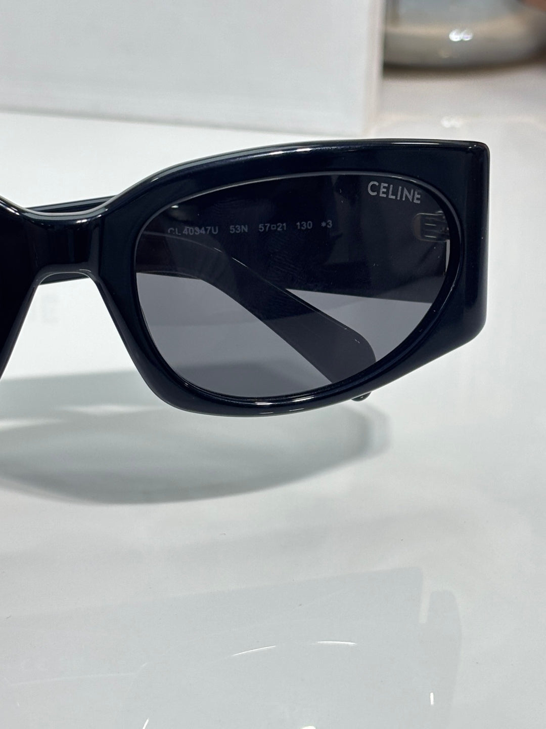 Celine sunglasses, glossy dark frame with dark shield-shaped lenses and Celine logo