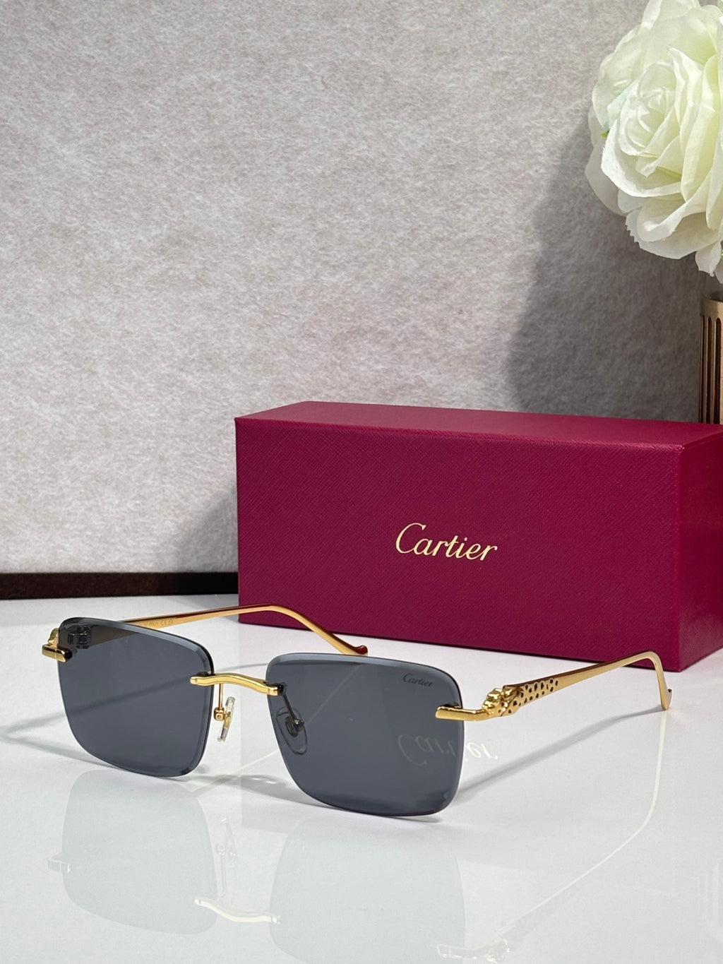 Cartier glasses with gold-tone frames and dark gray lenses, with burgundy box