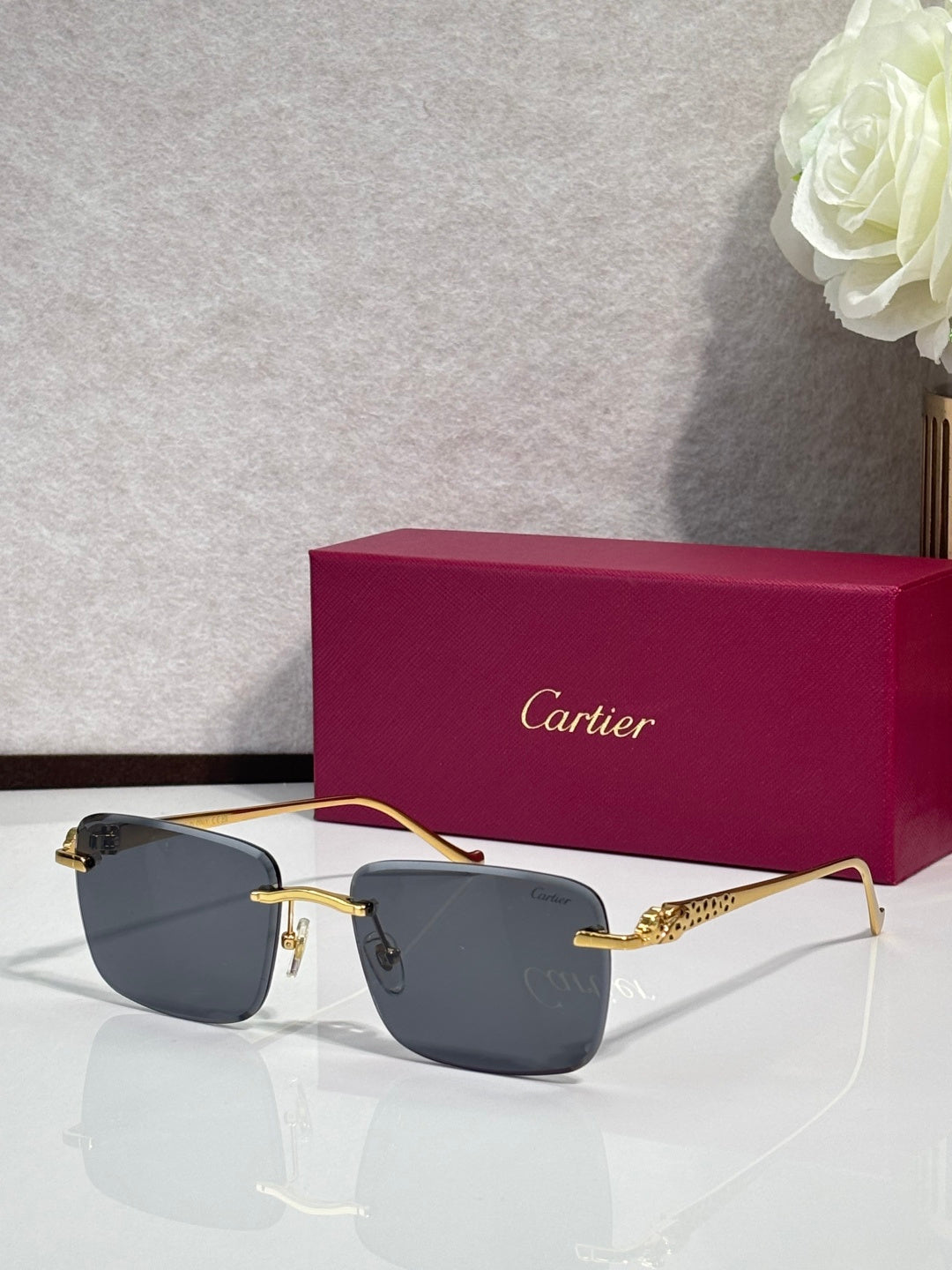 Cartier glasses with gold-tone frames and dark gray lenses, with burgundy box