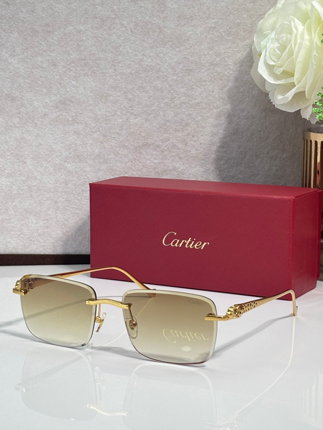 Cartier glasses with gold-tone frames and pale yellow-tinted lenses, with burgundy box