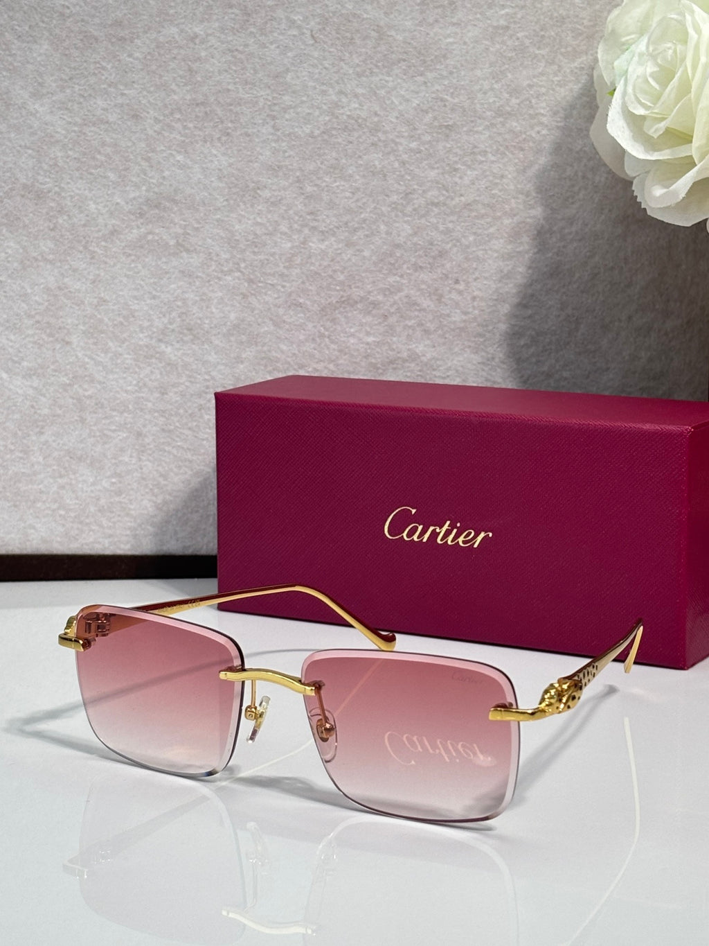 Cartier glasses with gold-tone frames and pink-tinted lenses, with burgundy box