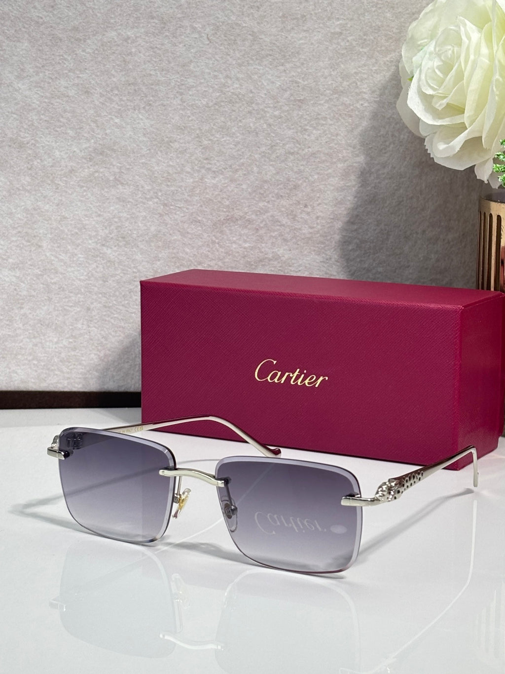 Cartier glasses with gold-tone frames and gray-tinted lenses, with burgundy box