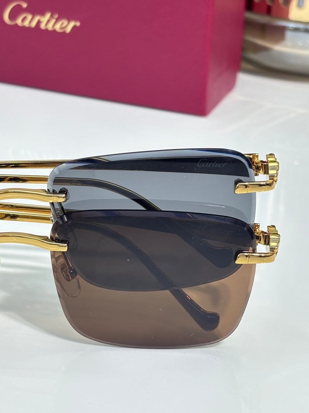 Cartier glasses close-up with gold-tone rims and layered dark-tinted lenses