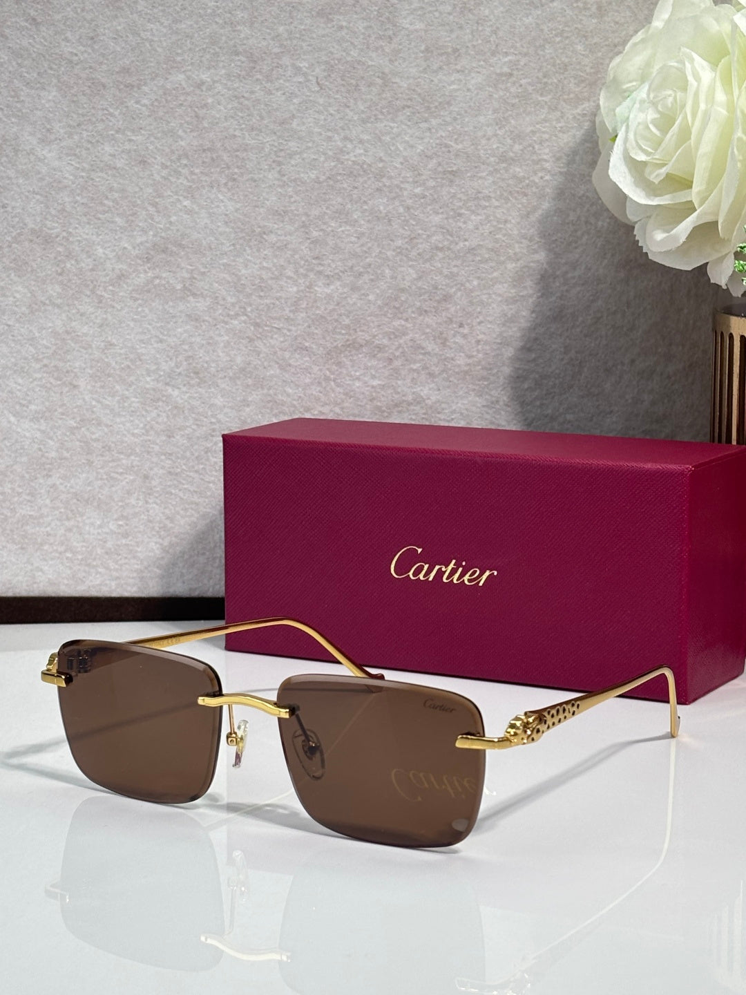 Cartier glasses with gold-tone frames and brown-tinted lenses, with burgundy box