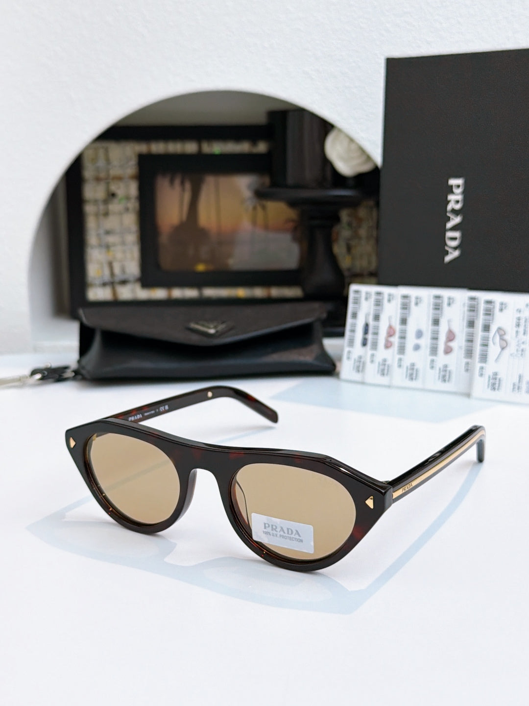 Prada sunglasses with black acetate frames and tan lenses, metal temple tips.
