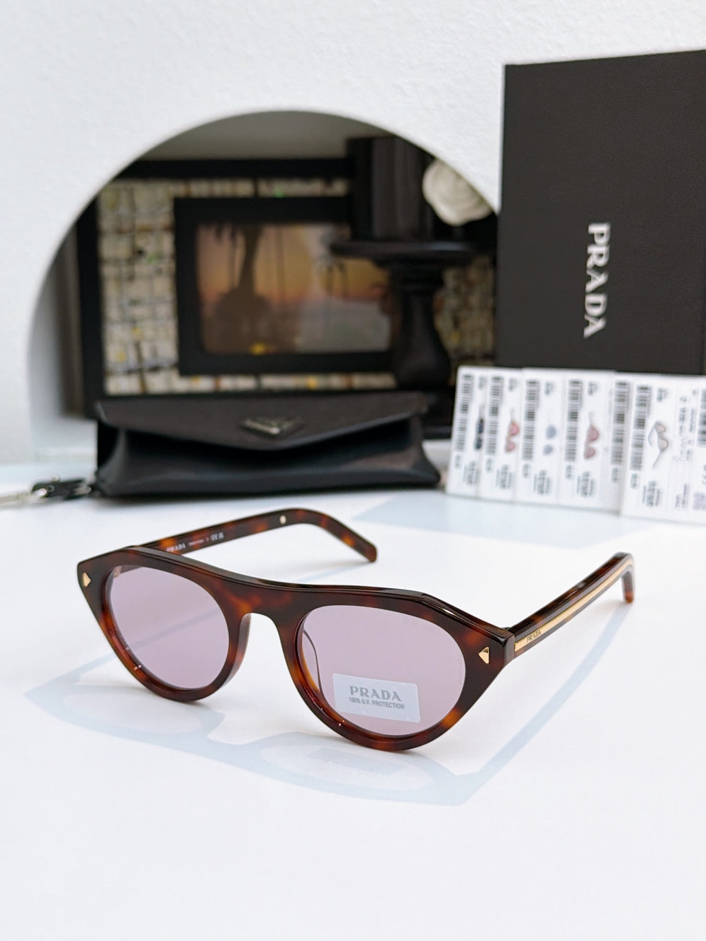 Prada sunglasses with tortoiseshell acetate frames and tan lenses, metal temple tips.
