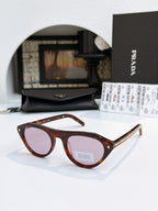 Prada sunglasses with tortoiseshell acetate frames and tan lenses, metal temple tips.