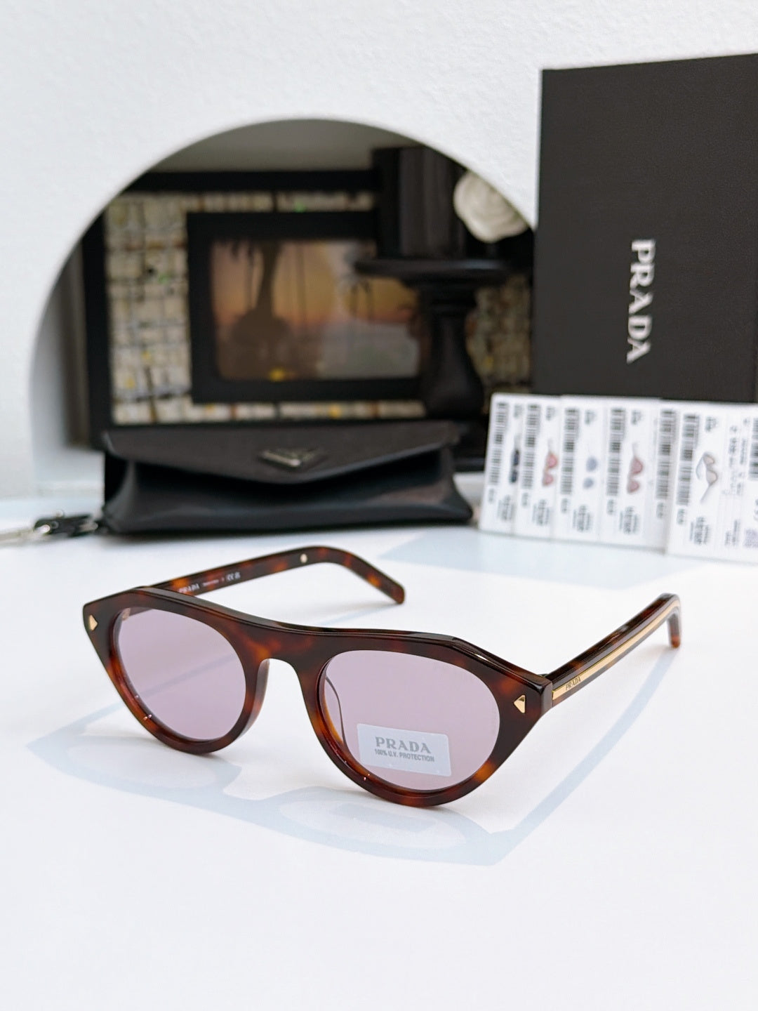 Prada sunglasses with tortoiseshell acetate frames and tan lenses, metal temple tips.