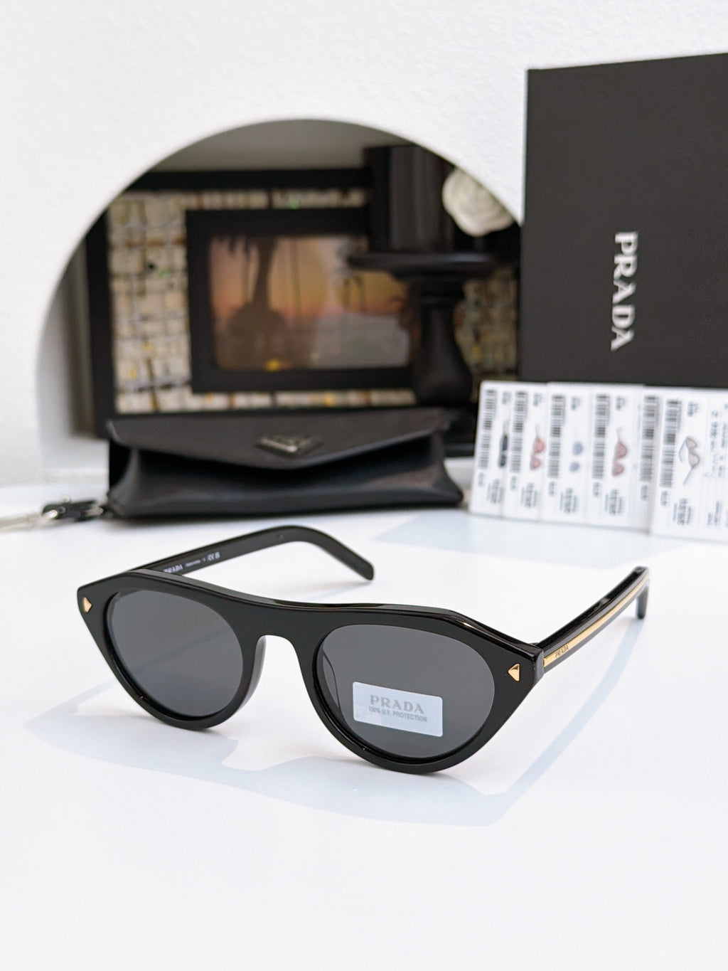 Prada sunglasses with black acetate frames and dark lenses, metal temple tips.