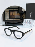 Prada sunglasses with black acetate frames and light tan lenses, gold-trim temple detail.