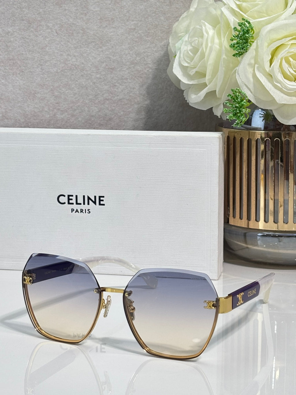 Celine sunglasses with blue-tinted lenses and gold-tone frame, rounded square