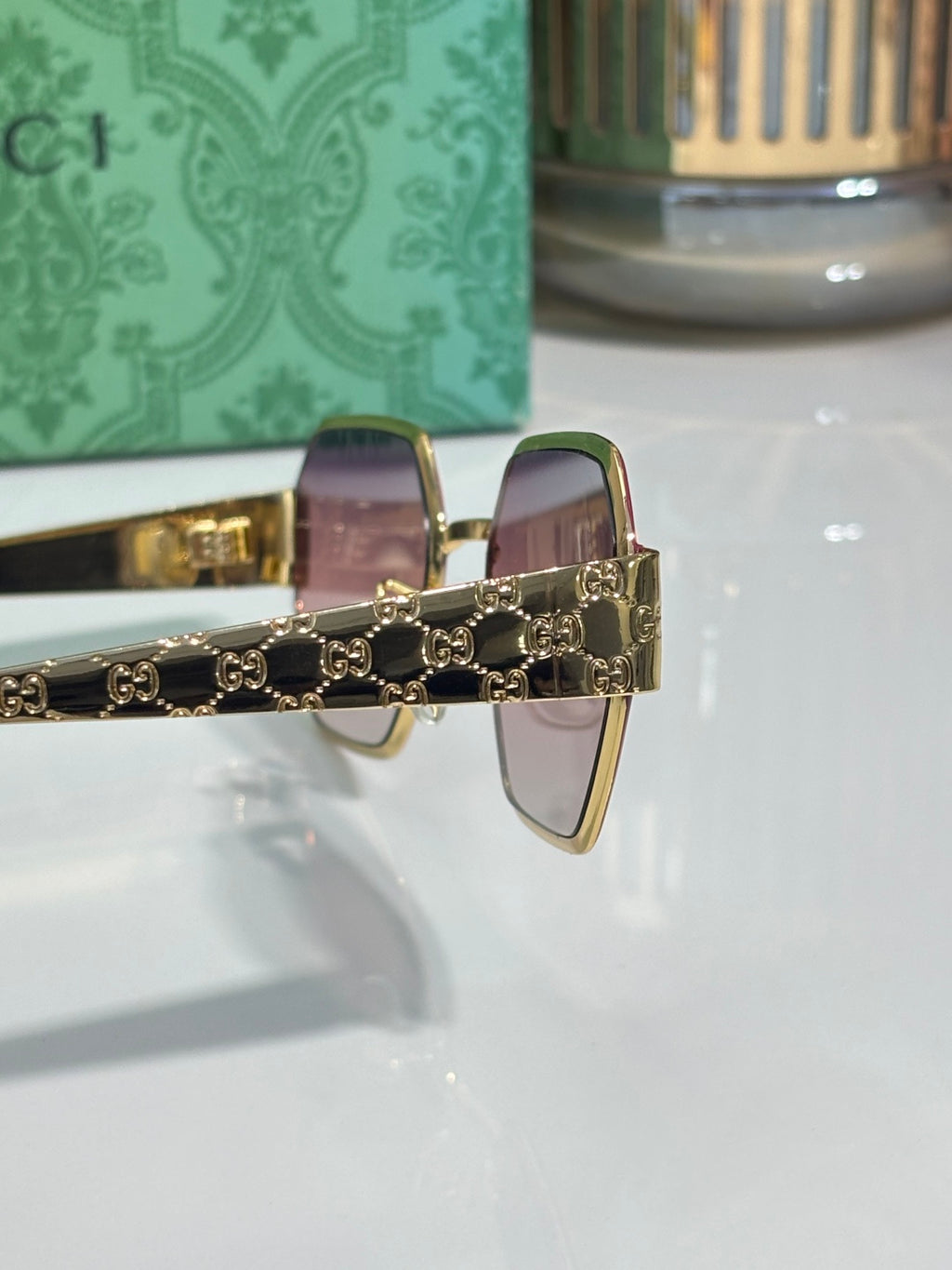 Gucci sunglasses with pink lenses and gold-tone chain detail
