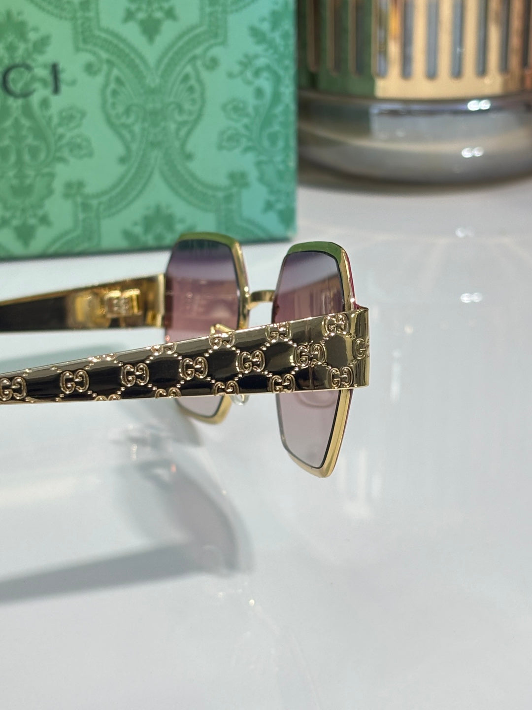 Gucci sunglasses with pink lenses and gold-tone chain detail