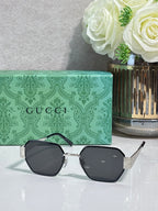 Gucci hexagon sunglasses with black lenses and gold-tone metal frame