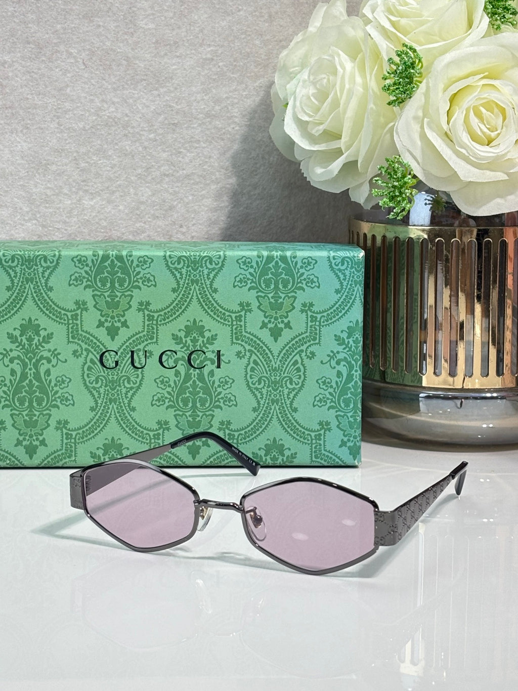 Cat-eye sunglasses with light purple lenses, dark frame, and patterned temple details.
