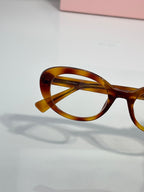 Tortoiseshell eyeglasses with curved browline and round optical lenses