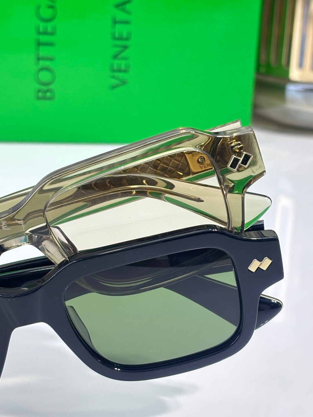 Bottega Veneta navy oval glasses with gold temple accents and logo hinges