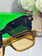 Bottega Veneta dark glasses with amber-tinted front and gold side logo hardware