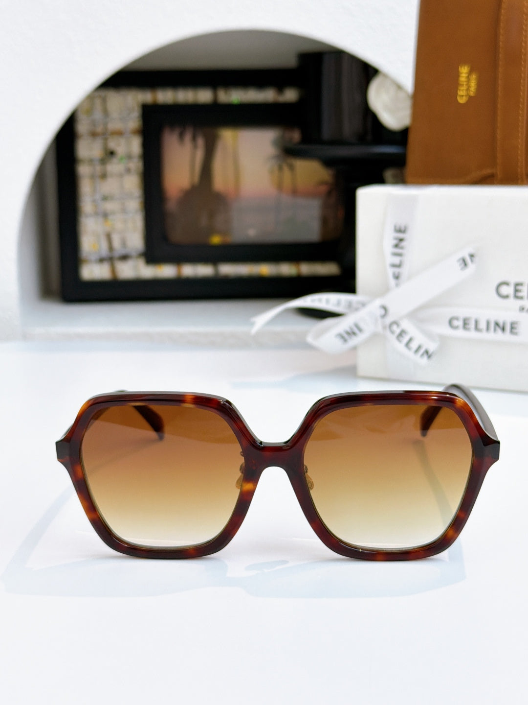 Tortoiseshell square sunglasses with brown gradient lenses and gold hinge detail.