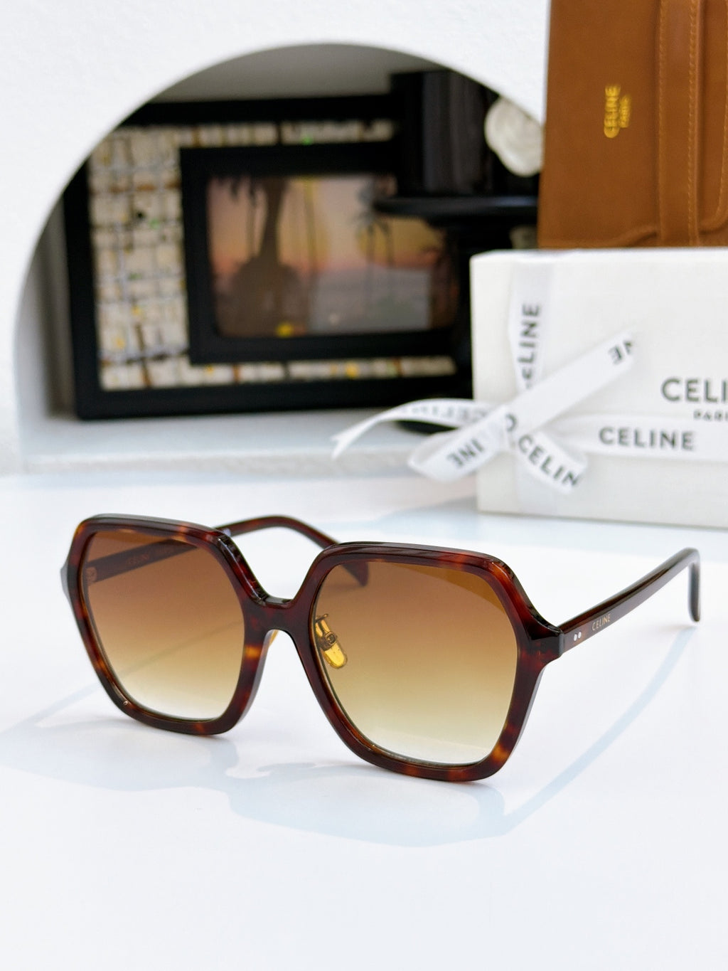 Tortoiseshell square sunglasses with amber lenses and gold hinge detail.