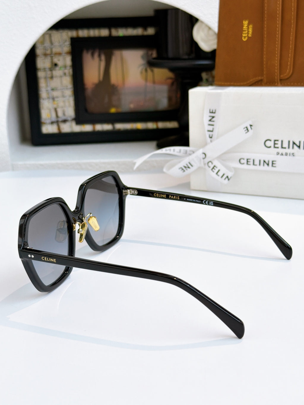 Black square eyeglasses shown from the side, gold hinge detail and clear lenses.