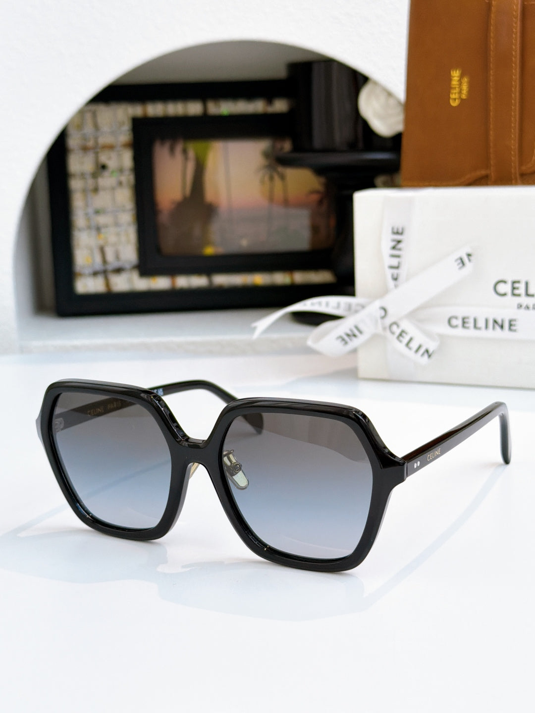 Black square sunglasses with dark lenses and gold hinge detail.