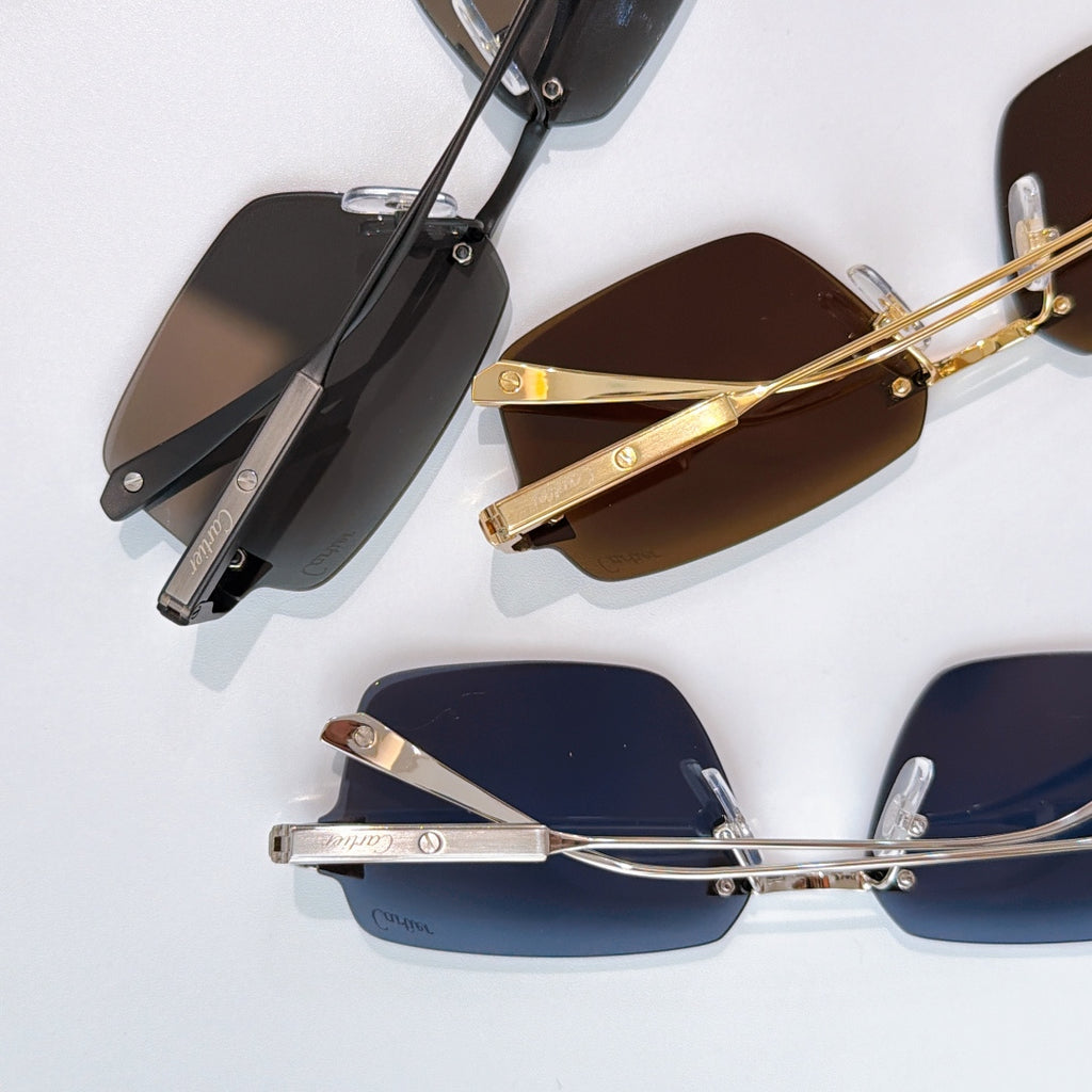 Multiple rectangular sunglasses with different colored lenses and metal frames, side view.