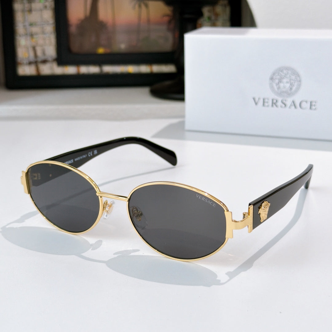 Sunglasses with gold frame and dark lenses, with black temple arms