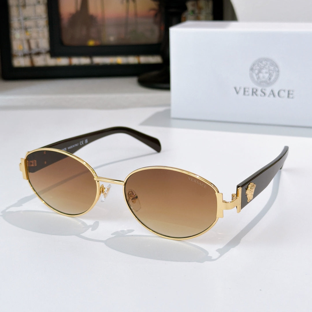 Sunglasses with gold frame, amber lenses, and black temple arms
