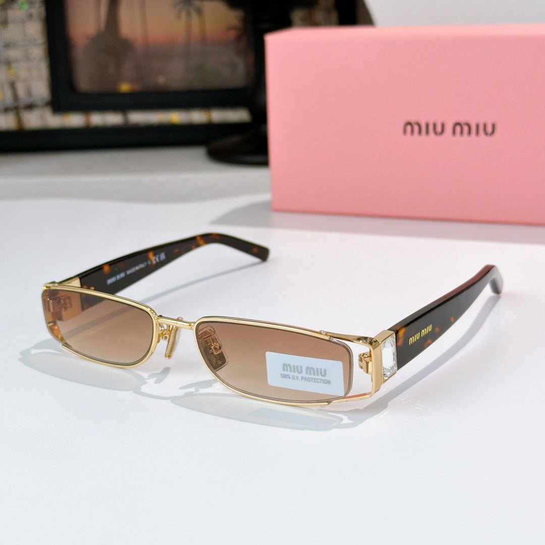 Designer sunglasses with tan gradient lenses, gold frame, and black temple tips