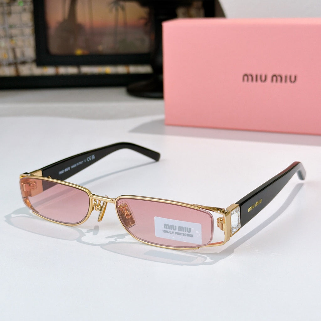Designer sunglasses with pink-tinted oval lenses, gold frame, and black temple tips