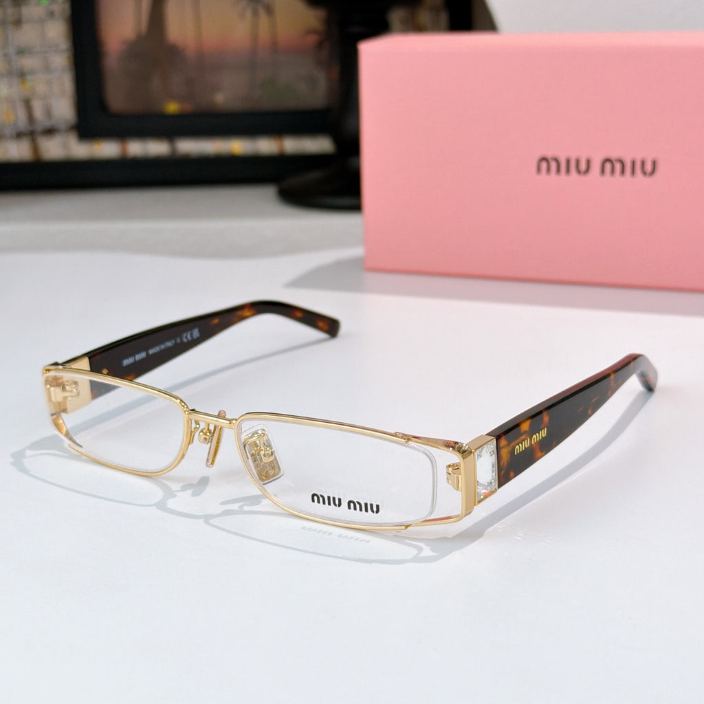 Designer eyeglasses with clear oval lenses, gold frame, and black temple tips