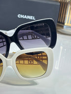 Chanel sunglasses close-up, white and navy frames with tinted lenses