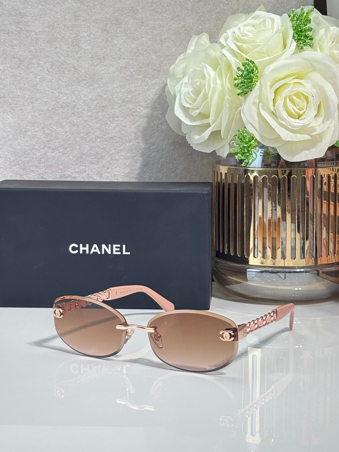 Chanel sunglasses with blush lenses, pink frame and gold chain arms