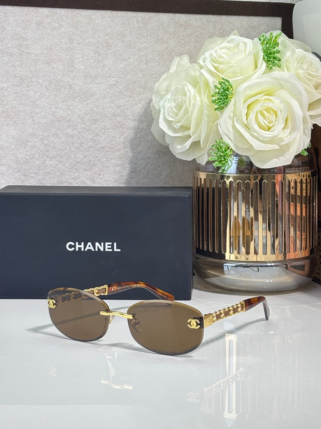 Chanel sunglasses with taupe lenses, gold-brown frame and chain arms