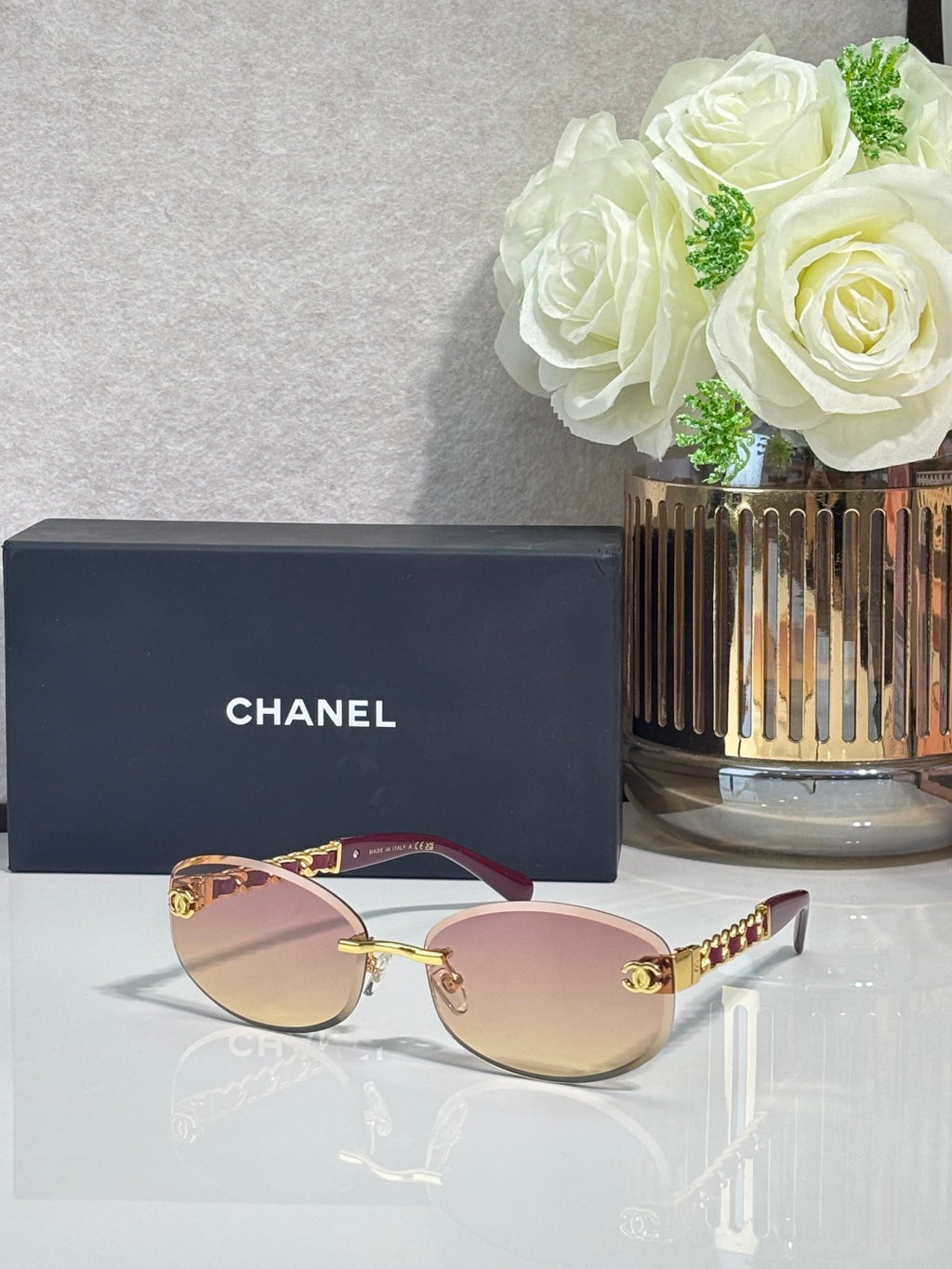 Chanel sunglasses with rose-tinted lenses, pink frame and gold chain arms