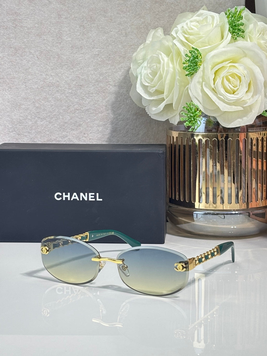 Chanel sunglasses with blue lenses, gold-trim frame and chain detail