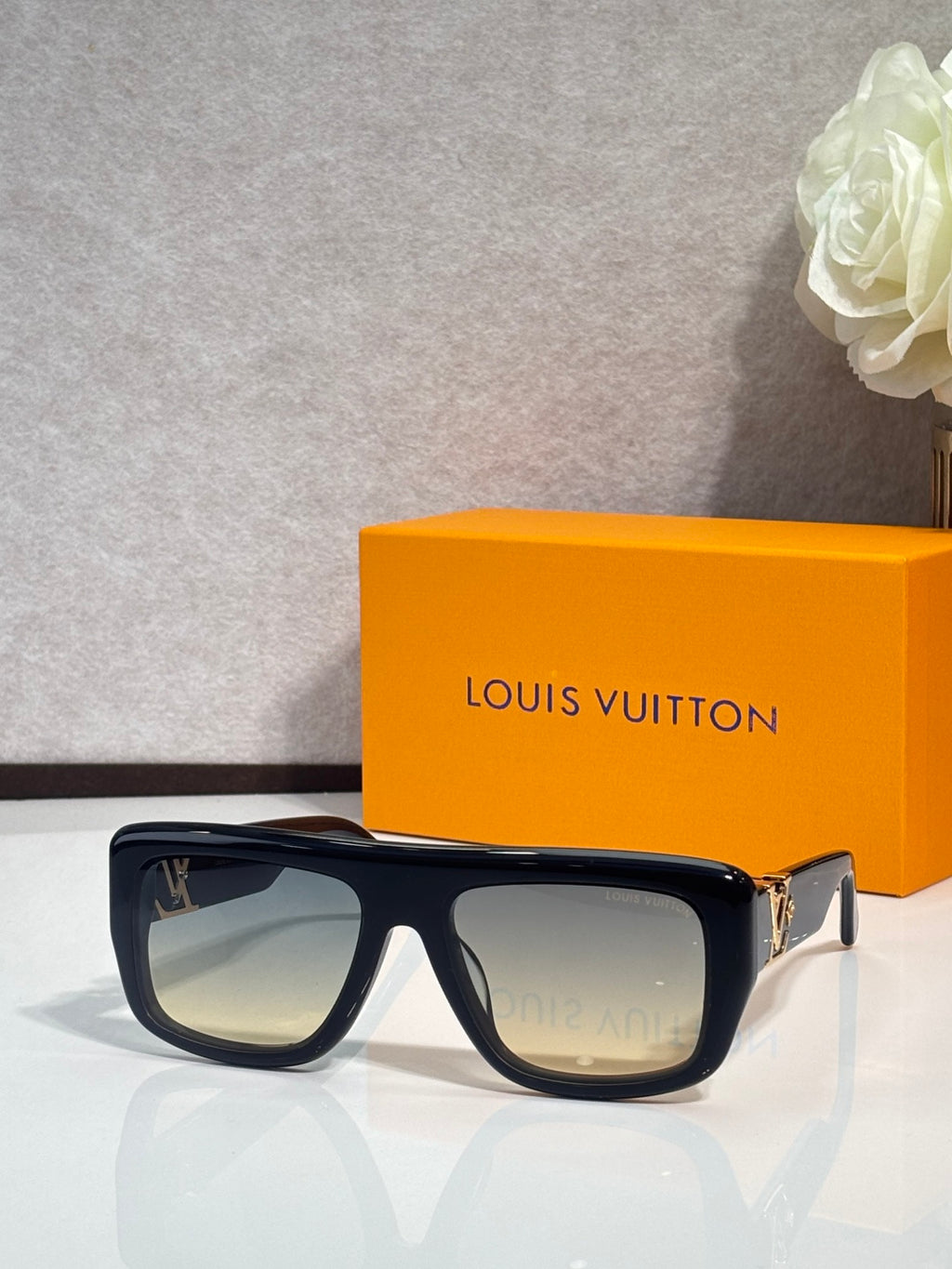 Black square sunglasses with tinted lenses and gold-tone hinge detail