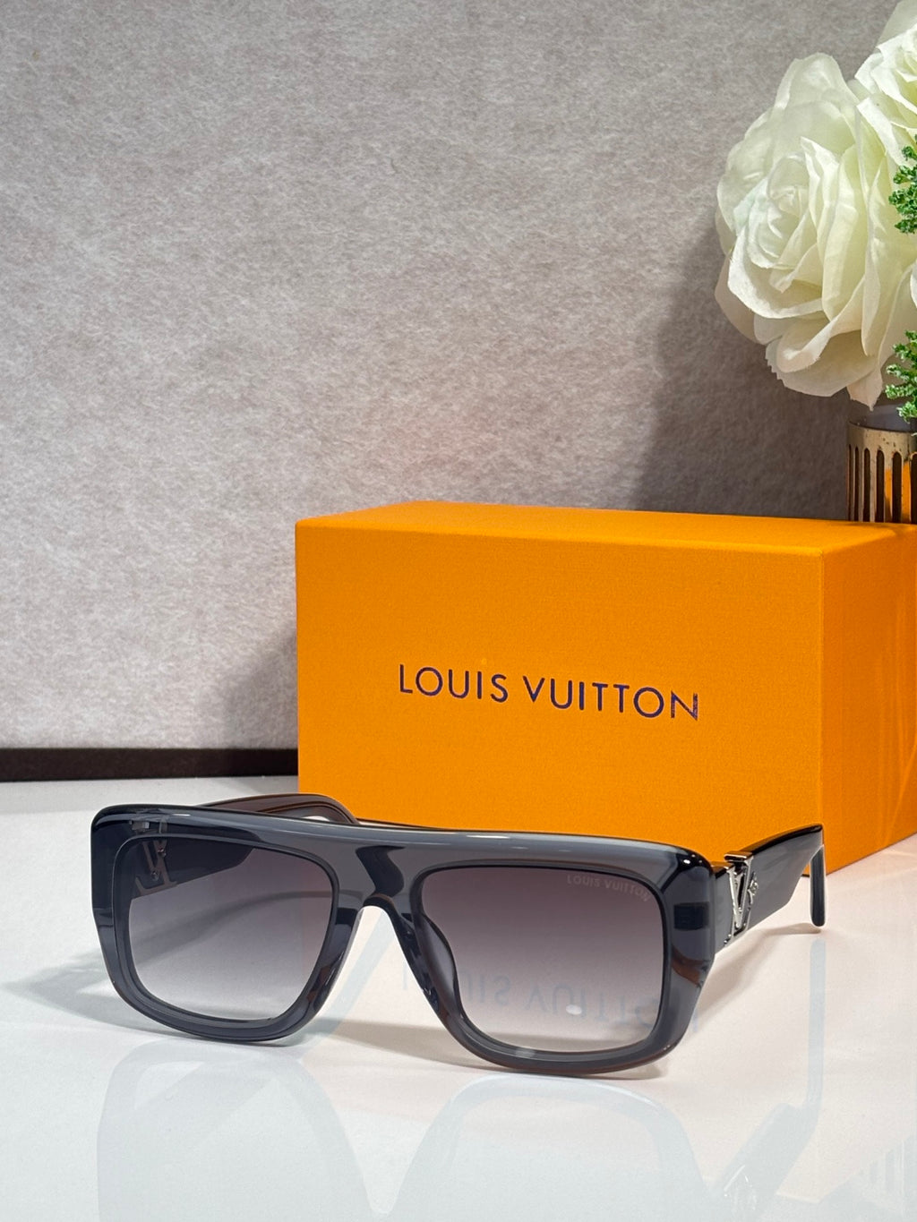 Dark blue square sunglasses with tinted lenses and gold-tone accents on hinges