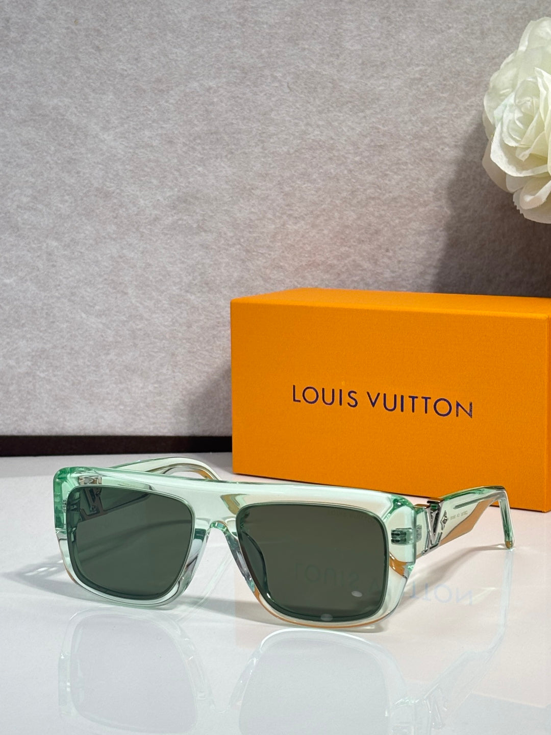 Light green square sunglasses with tinted lenses and gold-tone frame hardware