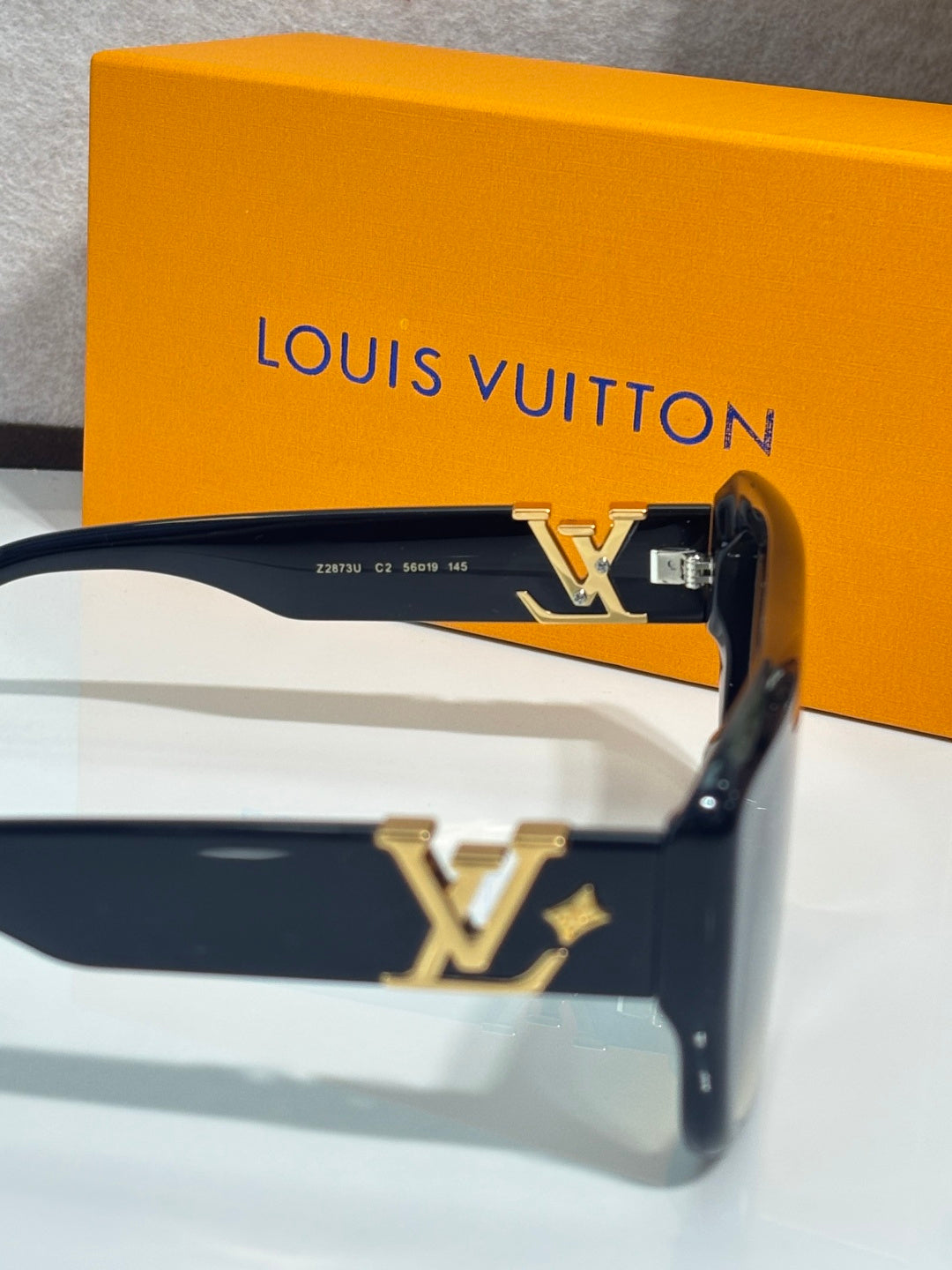 Dark blue square sunglasses with gold LV logo on temple and metal hinge