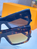 Louis Vuitton sunglasses close-up: blue frame with brown-tinted lenses and logo