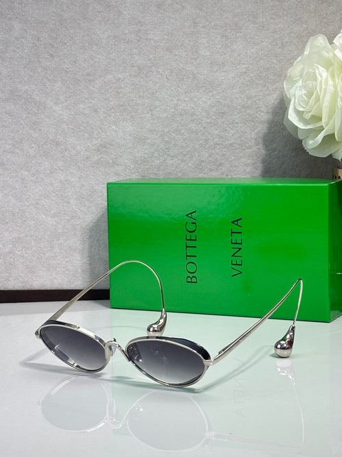 Silver oval sunglasses with dark lenses and curved metal arms