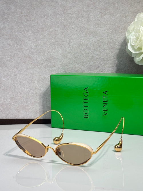 Gold oval sunglasses with tinted lenses and curved metal arms
