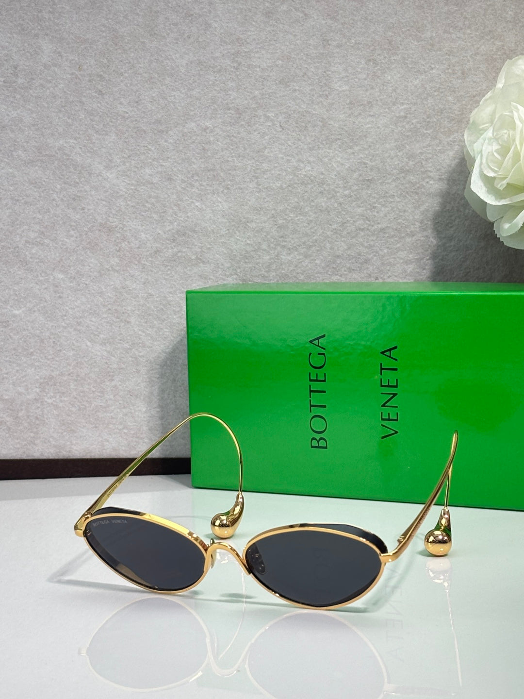 Gold oval sunglasses with dark lenses and curved metal arms