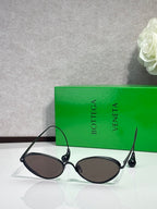 Black oval sunglasses with dark lenses and curved metal arms