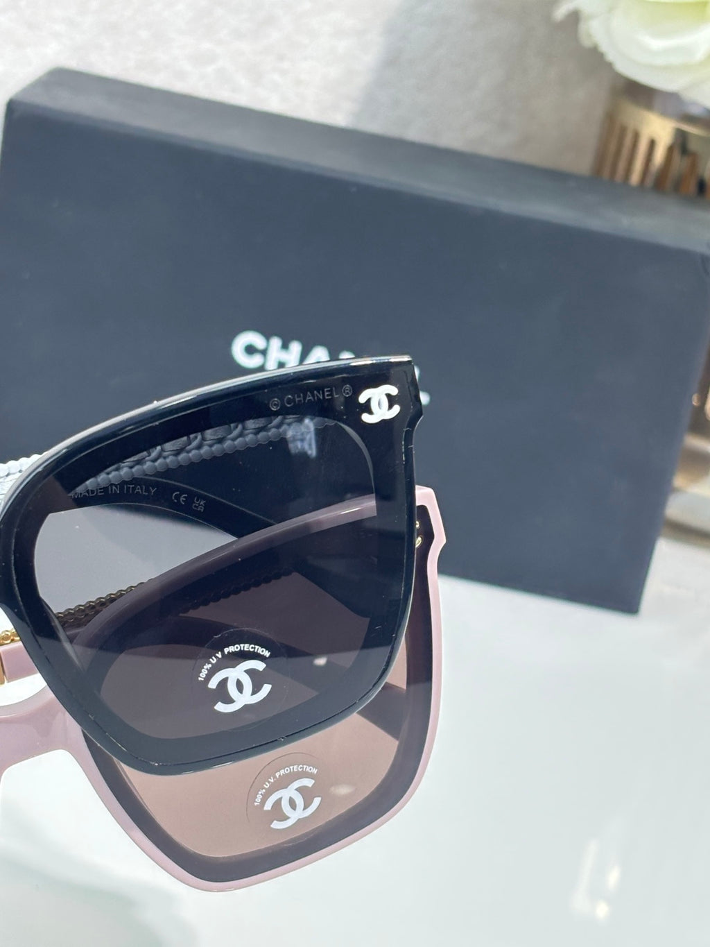 Chanel cat-eye sunglasses with pink edge, dark lenses, and logo bridge