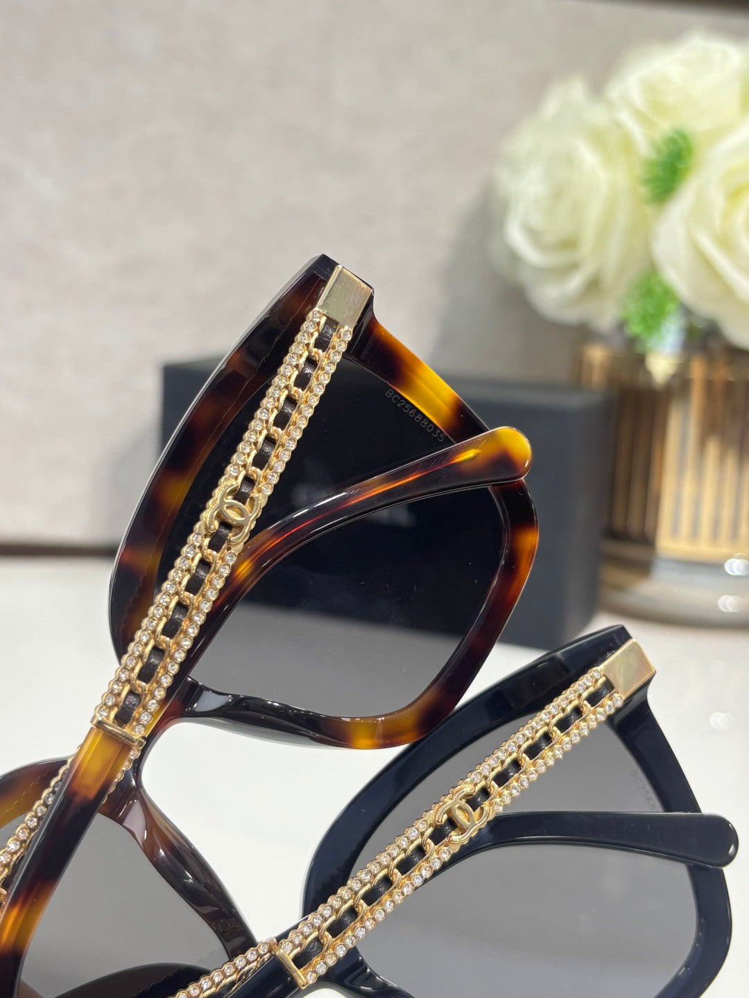 Chanel square sunglasses with tortoiseshell frames, gold rhinestone accents, and dark lenses
